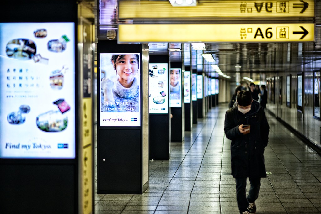 a person is walking by a row of digital signs