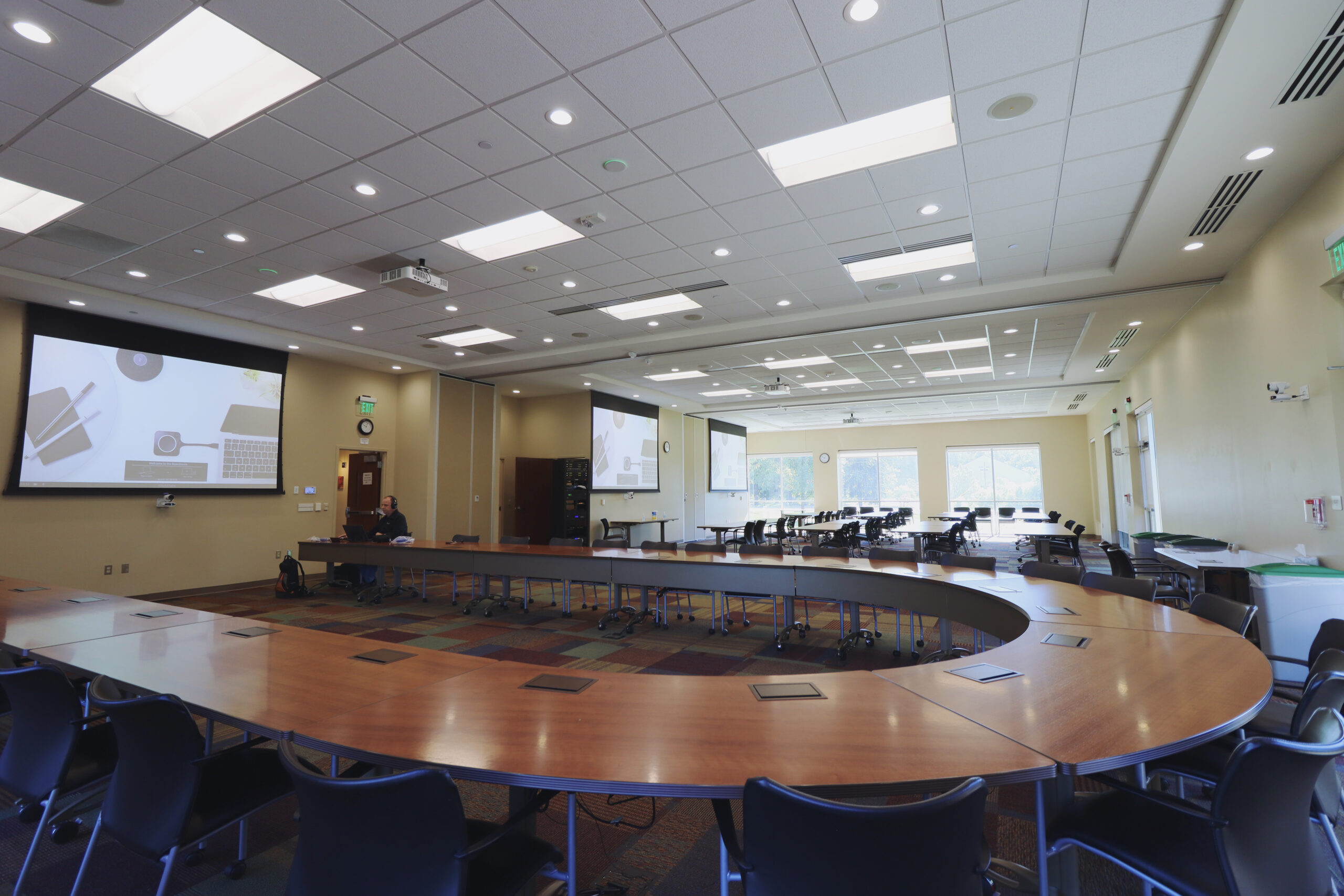 A very large conference space is opened up to show that all 3 rooms can be combined into one space and system. We are sitting on the Boardroom side looking over the table towards the other 2 spaces
